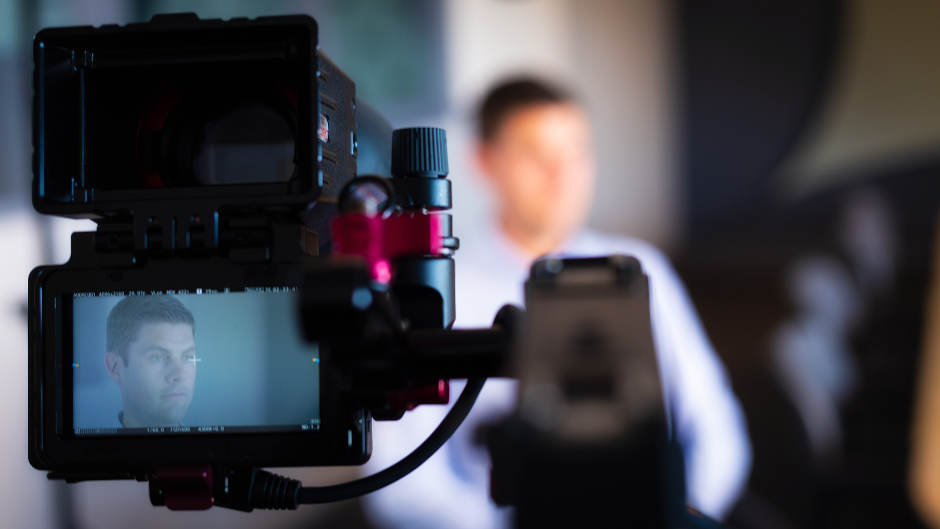 A view through a view finder of a camera looking at a man sitting down.